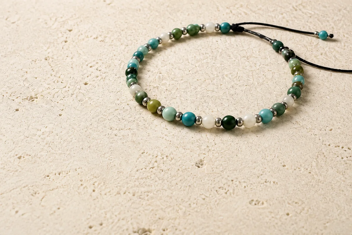 Pulsera ajustable de piedras naturales verdes y turquesa sobre piedra caliza
